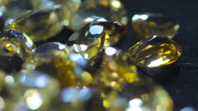 Precious gems falling in slow motion over black background shot with red camera in jewelry workshop with a macro lens