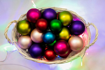 New year's background. Christmas composition with basket, multicolored christmas balls, a black background.