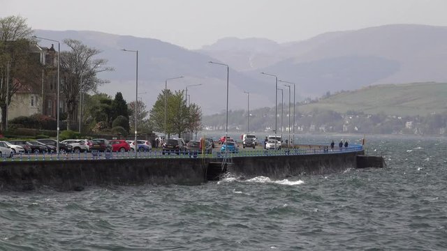 Choppy waters of the River Clyde on a windy day crashing against the esplanade wall at Greenock.