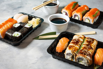 Various kinds of sushi served on concrete background