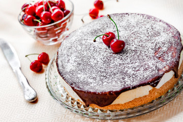 Bird's Milk souffle cake, covered with chocolate glaze and decorated with ripe juicy cherries