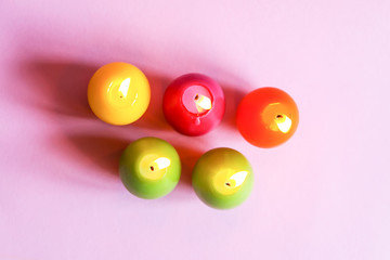 Traditional Easter decor. Group of bright burning paraffin candles in the shape of colorful eggs on...
