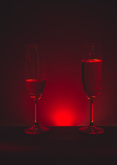 Glass of champagne on a dark background with a red halo
