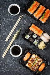 Various kinds of sushi served on black stone background.