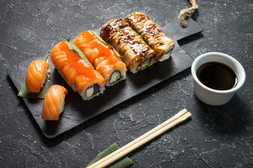 Various kinds of sushi served on stone background.