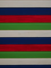 Detail of white, blue, red and green striped beach hut