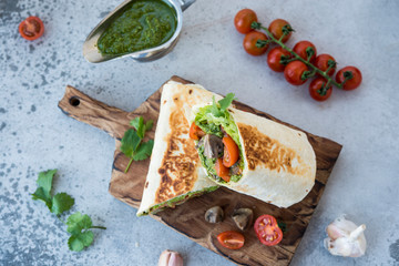 Burrito wraps with vegetables and sauce pesto.Roll with vegetables, mushrooms and pesto sauce. Vegetarian kebab. Of diet food.
