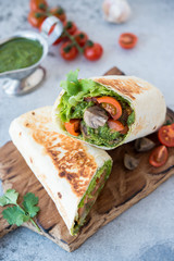 Burrito wraps with vegetables and sauce pesto.Roll with vegetables, mushrooms and pesto sauce. Vegetarian kebab. Of diet food.
