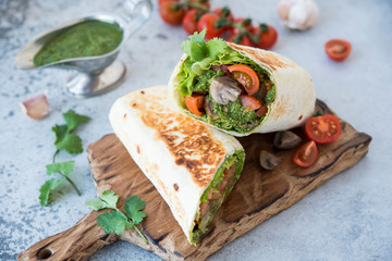 Burrito wraps with vegetables and sauce pesto.Roll with vegetables, mushrooms and pesto sauce. Vegetarian kebab. Of diet food.