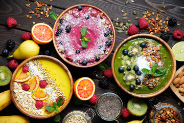 Fototapeta na wymiar Smoothie bowls. Healthy breakfast bowl with chia seeds, muesli, berries, fruits and coconut flakes coconut flakes. Vegan food