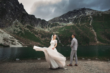 Wedding couple walking near the lake in Tatra mountains in Poland. Morskie Oko. Beautiful summer day