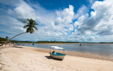 Tropical island with coconut trees and boat in the sand