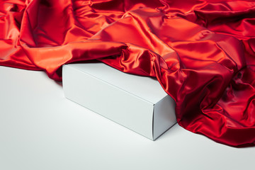 Close up of white blank box under red cloth on white background. 3d rendering.