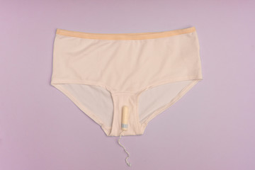Menstruation concept with panties, tampons and pads on bright blue background. Woman menstruation...