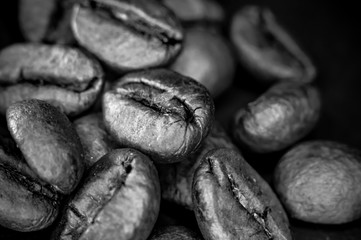 Brown roasted coffee beans on black background, close up, macro