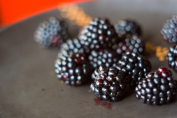 large juicy blackberry berries on a ceramic plate