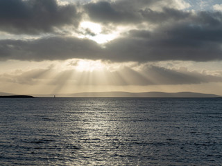 Obraz premium Dramatic sky and sun beams over Burren mountains, West coast of Ireland. Atlantic ocean.