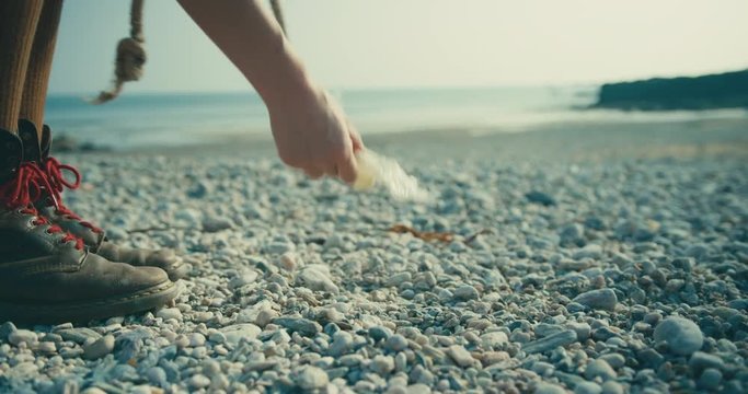 Young woman cleaning up plastic on the beach