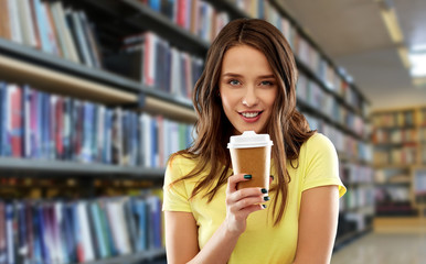 takeaway and people concept - young woman or teenage girl in yellow t-shirt drinking coffee over library background