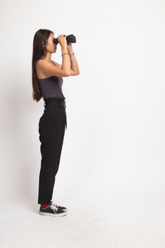 Full body of young Asian woman with binoculars.