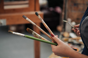 Brushes in the hands of the artist's women. Drawing and art.