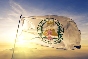 Tamil Nadu state of India flag waving on the top sunrise mist fog