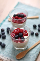 Simple no-bake raspberry cheesecake in a glass. Decorated with blueberries. Selective focus.