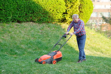 man mows the lawn grass with a lawn mower