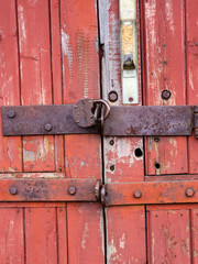 Iron lock hanging on the old wooden gate.