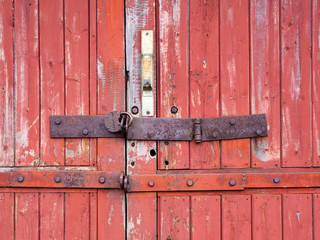 Iron lock hanging on the old wooden gate.