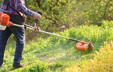man mows the lawn grass with a lawn mower