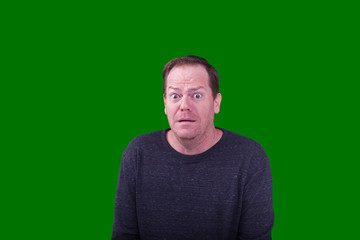 Obraz premium Portrait of a man with terrified facial expression photographed on green screen background 