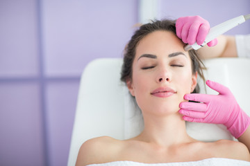 Beautiful woman in professional beauty salon during photo rejuvenation procedure