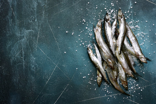 Raw capelin fish with salt.Top view with copy space.