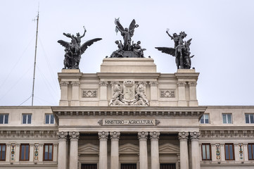 Fototapeta na wymiar Sculptures on a top of Formento Palace, seat of Agriculture Ministry in Madrid, capital city of Spain