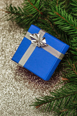 Small blue box christmas gift background. Surprise present with silver ribbon.