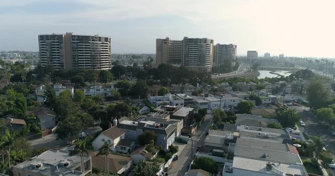 Buildings in Marina Del Rey, California. Aerial drone stock footage by Airflow Creations. sunset, houses, sun, sky, canals, water, streams, beach, mountains, ocean, sea, shore, coastline, cityscape, 