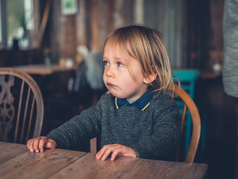 Little toddler sitting in a cafe