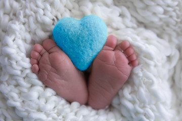 Fototapeta na wymiar child's legs on white. newborn baby feet. heart in the legs