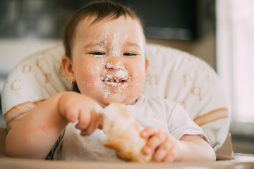 baby in the kitchen eagerly eating the delicious cream horns, filled with a vanilla cream