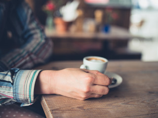 Fototapeta na wymiar Young woman drinking espresso in a cafe