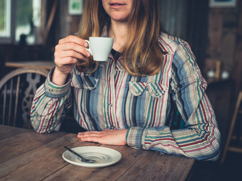 Young woman drinking espresso in a cafe