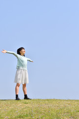 青空で手を広げる女の子
