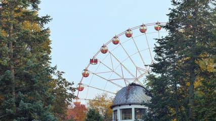 Ferris wheel rotates in a park in the foreground roof observatory