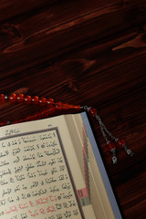 Islamic Holy Book Quran with rosary beads on wooden table background. Kuran the holy book os...