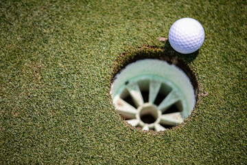golf ball and hole on grass