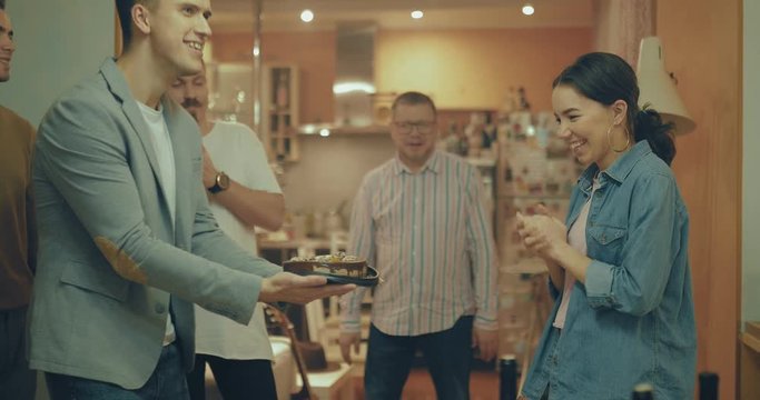 Girl birthday person dipped face in the cake and smeared on the face with cream. Company of friends is very fun to celebrate a birthday.