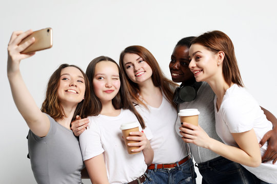 photo of five multiethnic  girls laughing and  taking selfie 