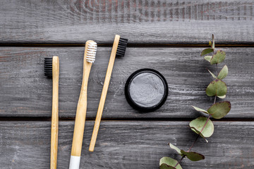 bamboo dental cleaning brush and carbon toothpaste for zero waste lifestyle concept on wooden background top view