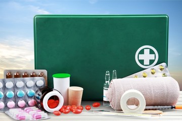 First aid kit  with medical supplies on light background